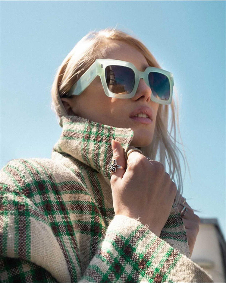 A trendy woman wearing Beachy Cover Ups' Trendy Large Frame Square Classy Sunglasses and a plaid coat.