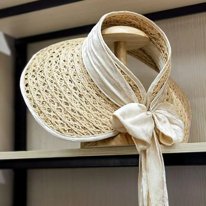 A Retro Ribbon Bowknot Beach Straw Visor by Beachy Cover Ups on a shelf.