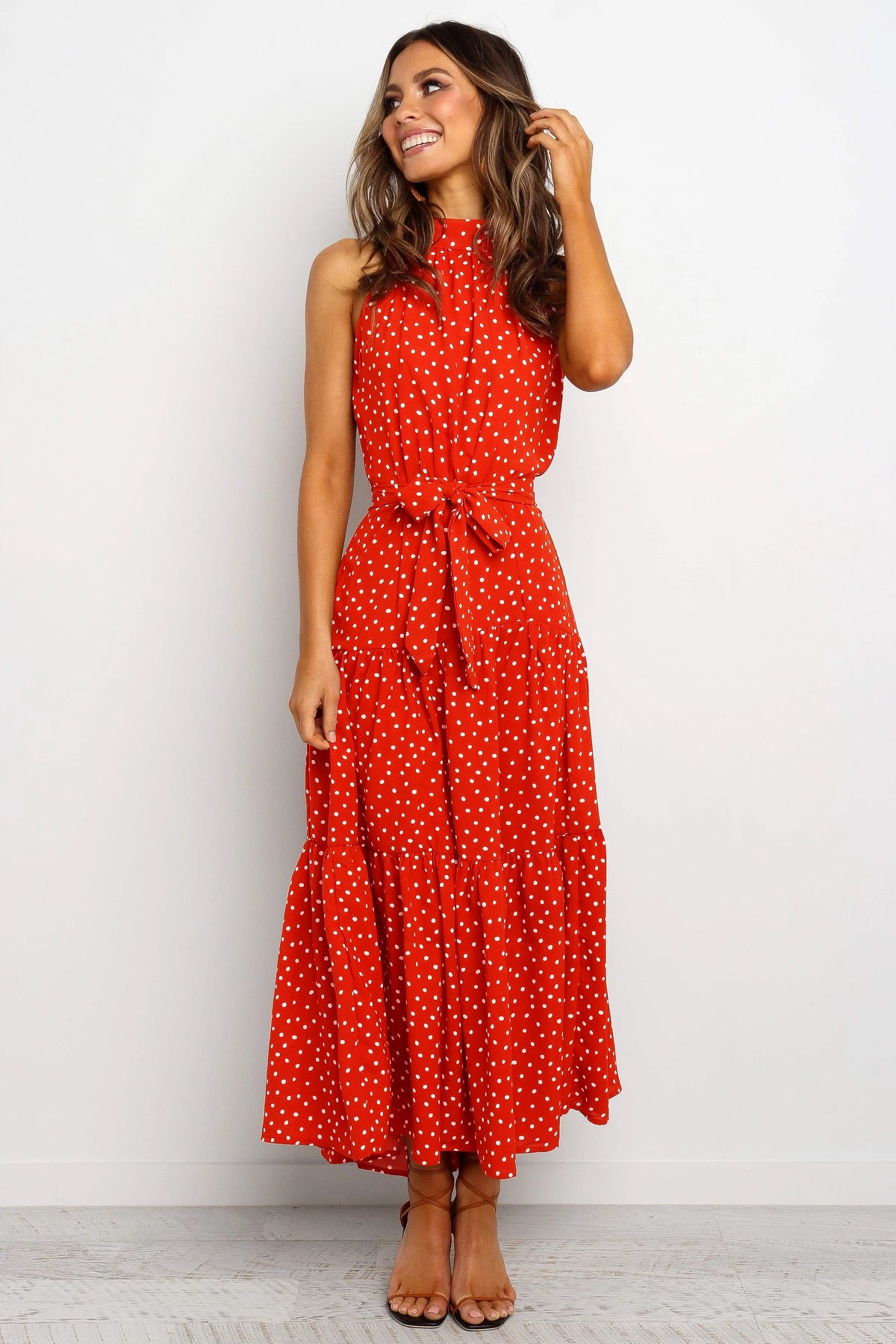 A woman wearing a Floral Or Polka Halter long Dress With Front Ribbon Tie by Beachy Cover Ups for customer service.