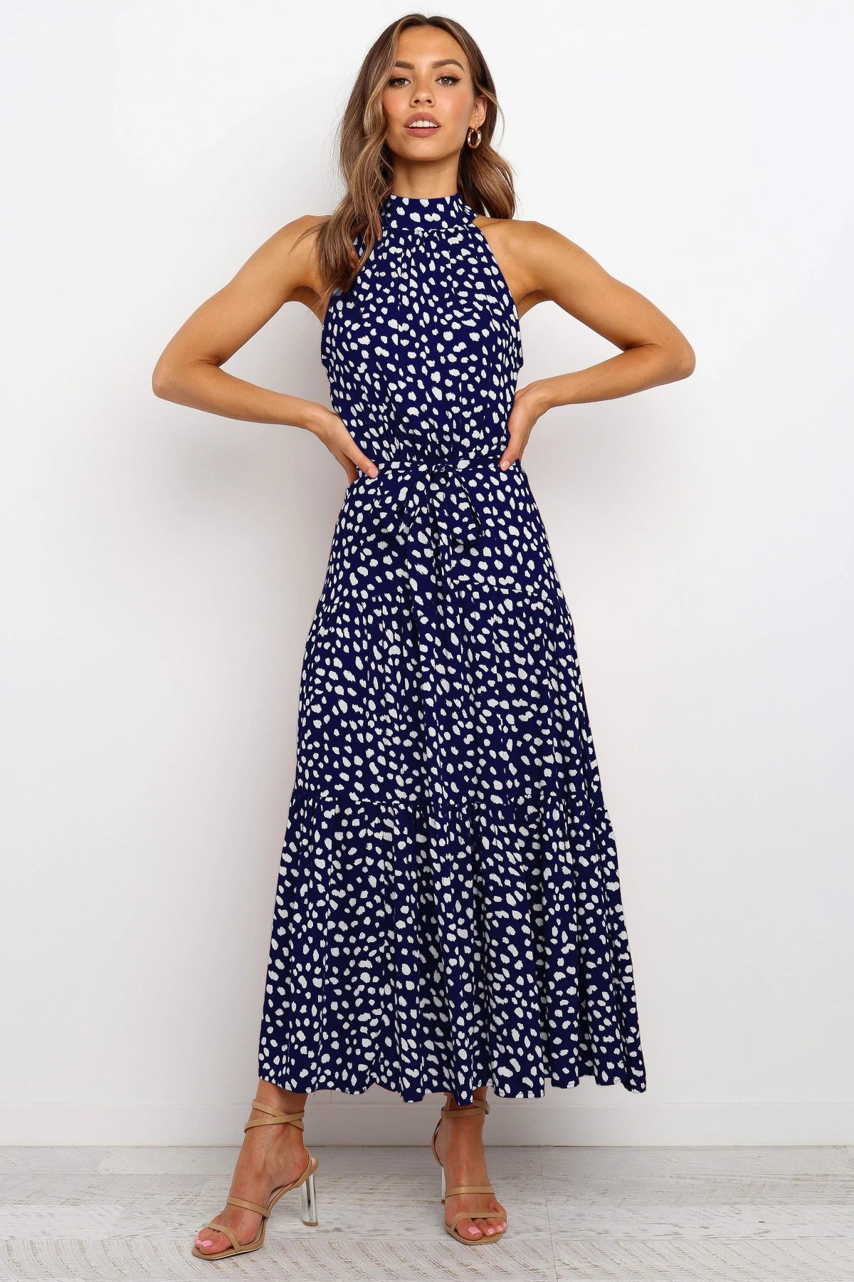 A model wearing a Floral Or Polka Halter long Dress With Front Ribbon Tie by Beachy Cover Ups that includes a size chart.