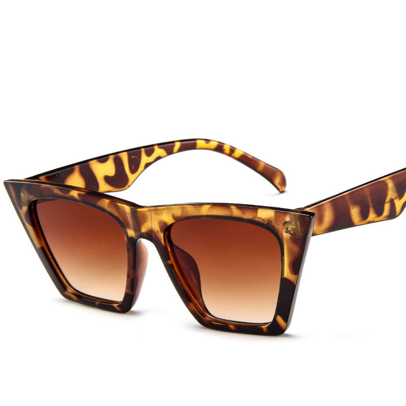 A pair of Trapezoid Retro Sunglasses with a leopard print frame, by Beachy Cover Ups.