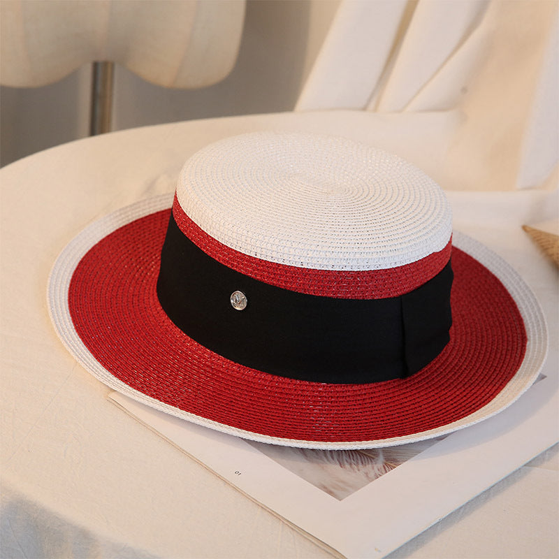 A Retro Flat Top Straw Beach Hat by Beachy Cover Ups on top of a table.