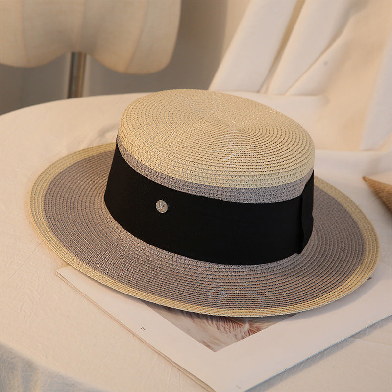 A Retro Flat Top Straw Beach Hat by Beachy Cover Ups resting on a white table, exuding beach vibes.