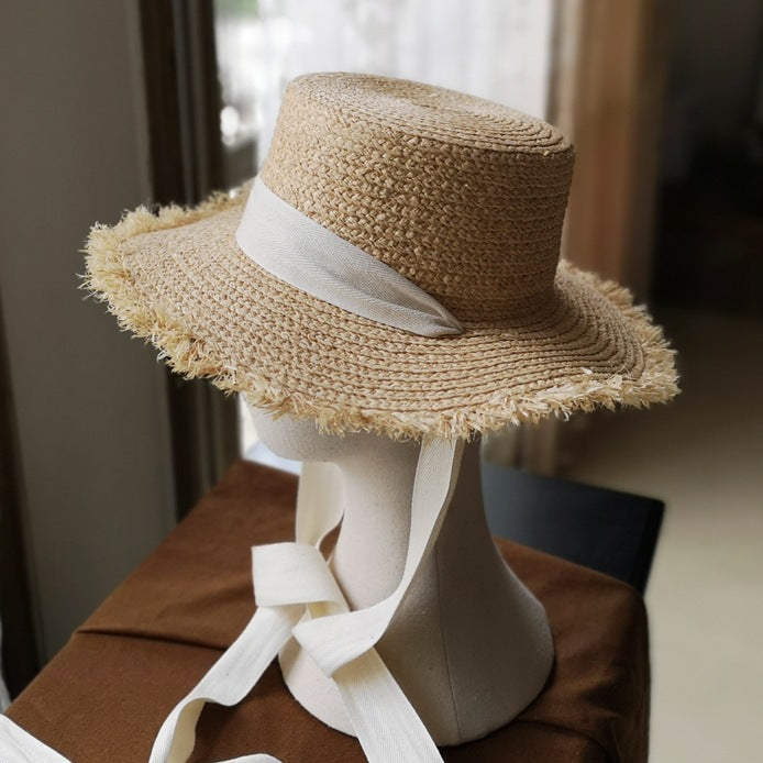 A mannequin wearing a Beachy Cover Ups Fringed Edge Straw Bowknot Sun Hat.