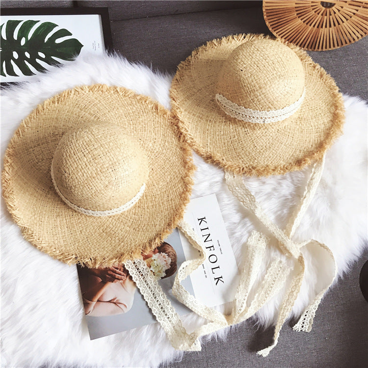 Two Fringed Beach Raffia Ribbon Straw Hats providing sun protection on a white fur rug beach ensemble by Beachy Cover Ups.