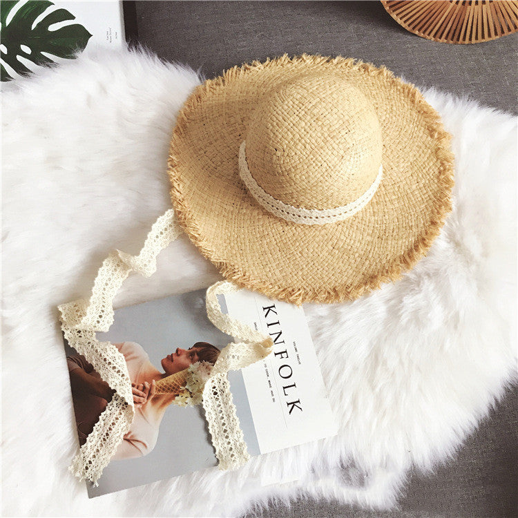A Fringed Beach Raffia Ribbon Straw Hat by Beachy Cover Ups, providing sun protection, is placed on a fur rug.