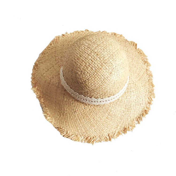 A Fringed Beach Raffia Ribbon Straw Hat from Beachy Cover Ups for sun protection in a beach ensemble.
