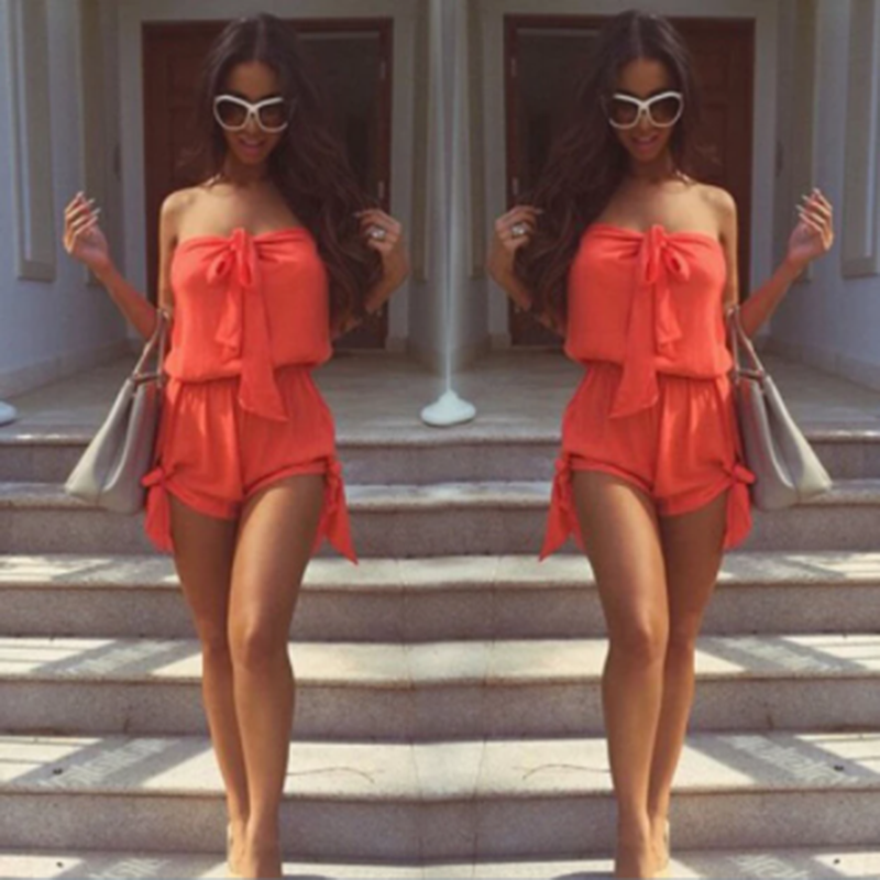 A woman wearing a Mini Romper Side Ties Summer Beach Dress from Beachy Cover Ups and sunglasses.