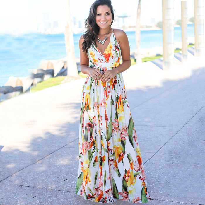 A woman showcasing tropical elegance in a Long Floral Resort Beach Dress by Beachy Cover Ups.