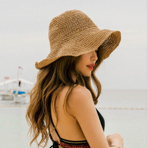 A woman in a Beachy Foldable Straw Hat wearing a bikini by Beachy Cover Ups.