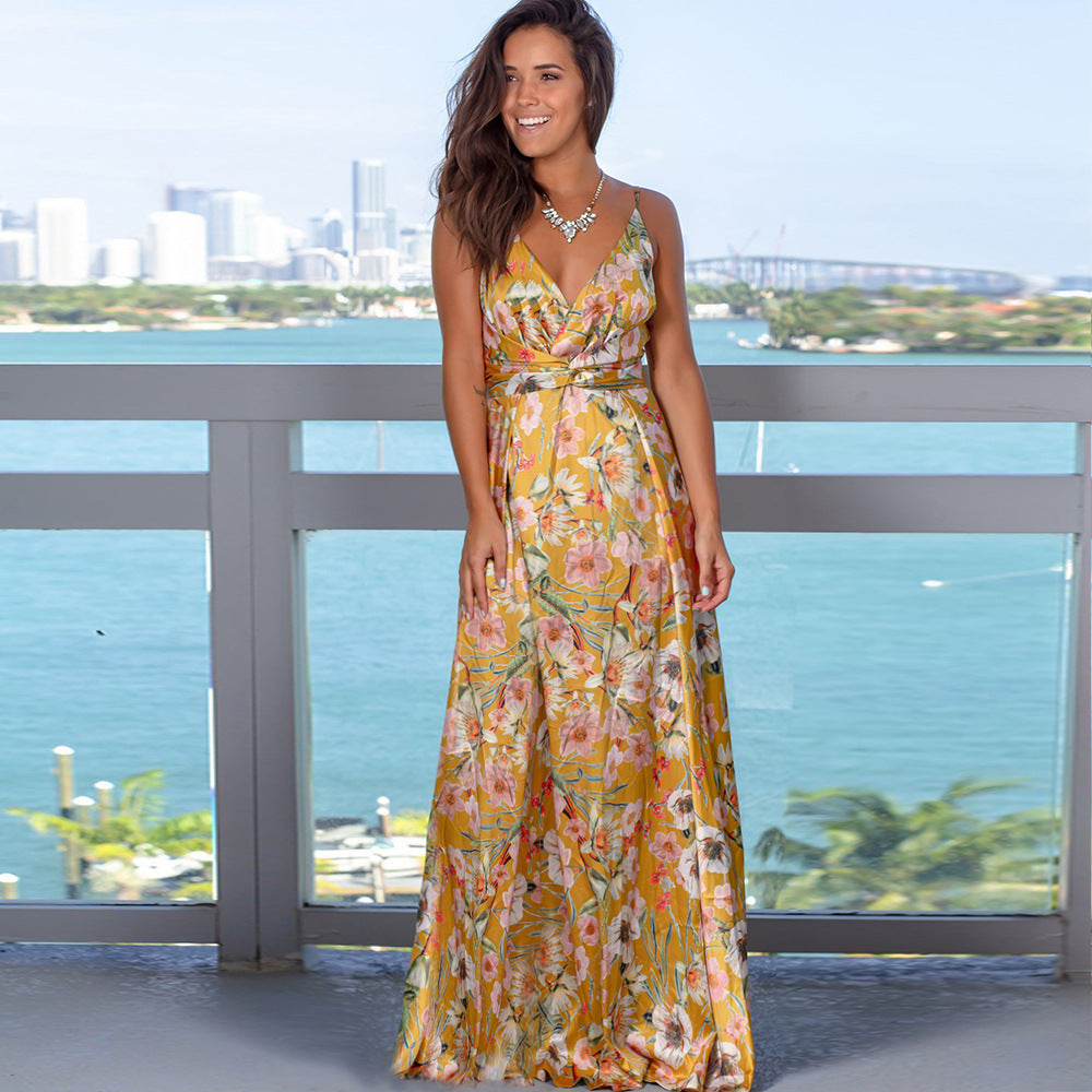 A woman in a Long Floral Resort Beach Dress by Beachy Cover Ups standing on a balcony overlooking the water.