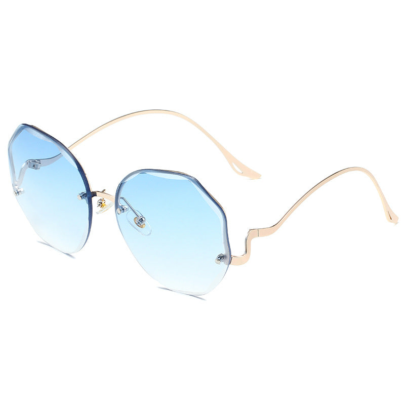 A pair of Beachy Cover Ups Irregular Shaped Rimless Cut Edge Sunglasses with an avant-garde gold frame and blue lenses.