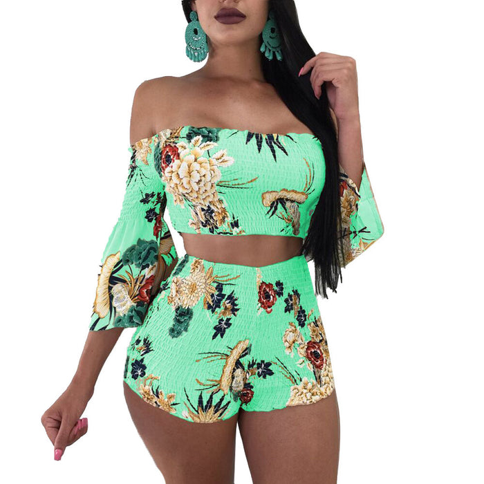 A woman in a Beachy Cover Ups green Floral Stretch Fabric Two-piece Beach Set off the shoulder top and high-waisted shorts.