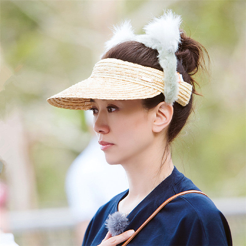 A woman wearing a Beachy Cover Ups Beach Woven Straw Sun Visor for sun protection.