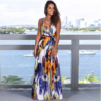 A woman wearing a Long Floral Resort Beach Dress by Beachy Cover Ups standing on a balcony.