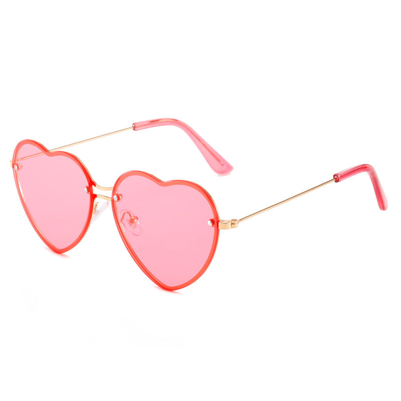A pair of Beachy Cover Ups heart-shaped rimless sunglasses on a white background, perfect for festive occasions and as a fashion accessory.