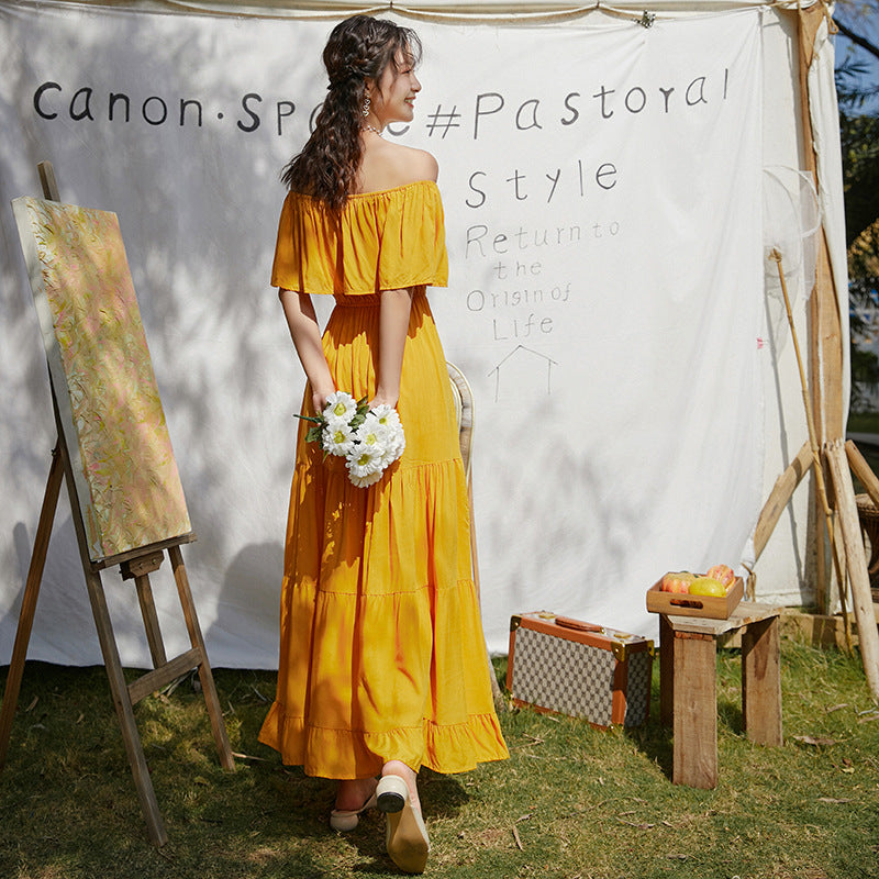 A woman in a Beachy Cover Ups one-shoulder Beach Umbrella Dress standing in front of a tent.