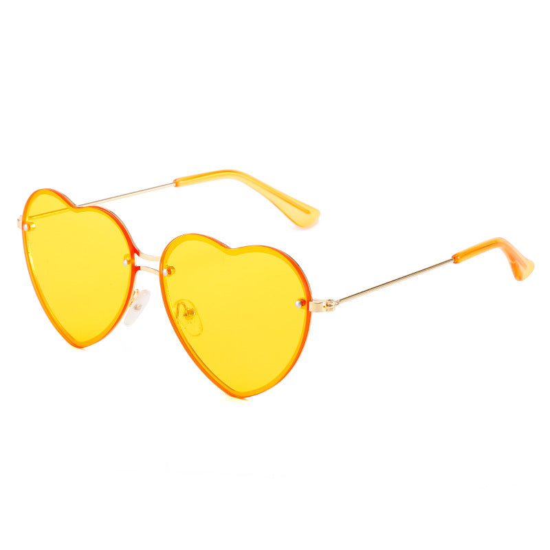 A pair of Beachy Cover Ups festive yellow Heart Shaped Rimless Sunglasses on a white background.