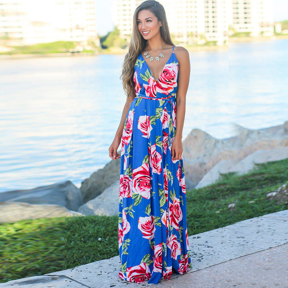 A woman in a Long Floral Resort Beach Dress by Beachy Cover Ups, posing by the water.