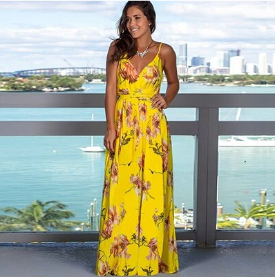 A woman is posing in a Long Floral Resort Beach Dress by Beachy Cover Ups.