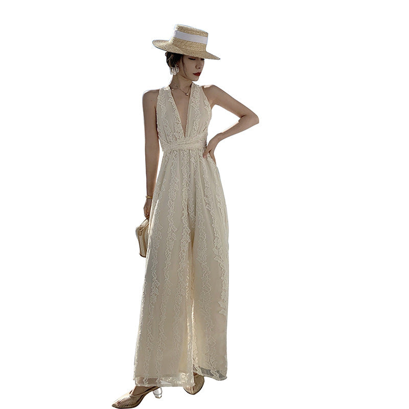 A woman in a white jumpsuit with a straw hat, wearing a High Waist Open Back Floral Apricot Beach Dress from Beachy Cover Ups.