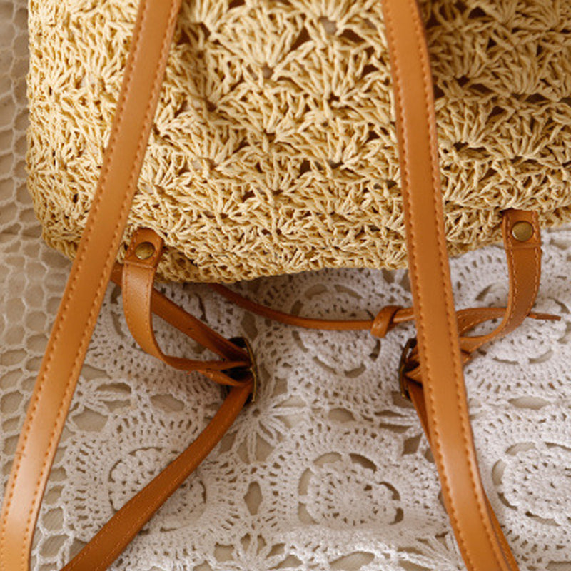 A Resort Holiday Straw Woven Beach Bag by Beachy Cover Ups sitting on a lace doily, perfect for resort wear or beach essentials.