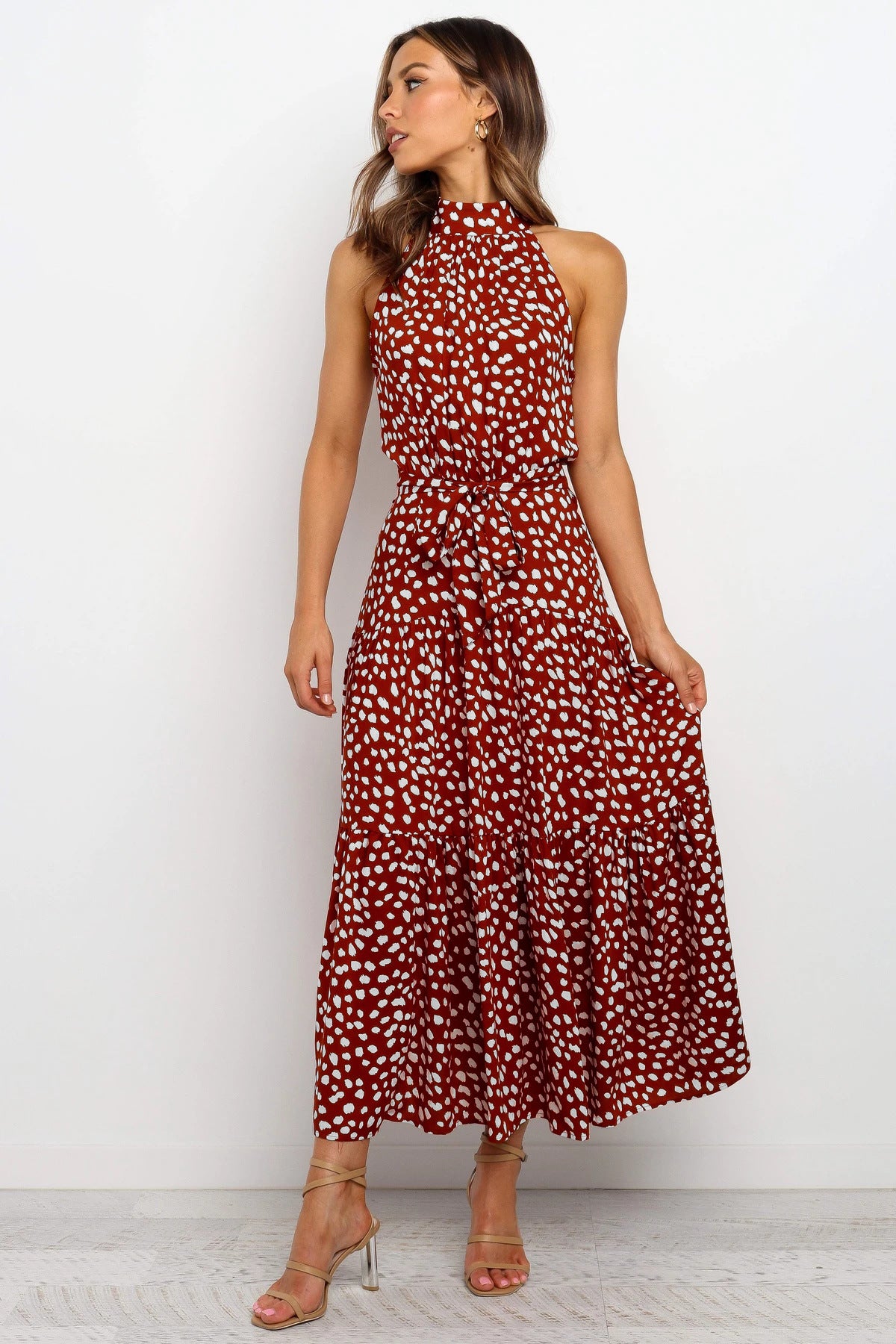 A woman wearing a Floral Or Polka Halter long Dress With Front Ribbon Tie made by Beachy Cover Ups.