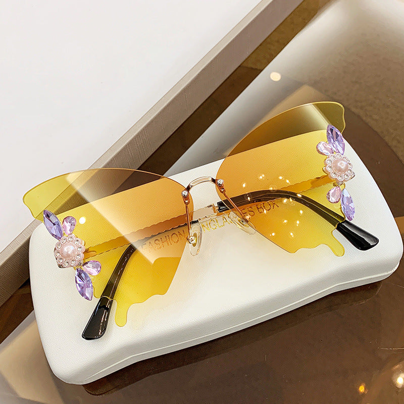 A pair of elegant Diamond Butterfly Sunglasses from Beachy Cover Ups with yellow frames and purple flower accents.