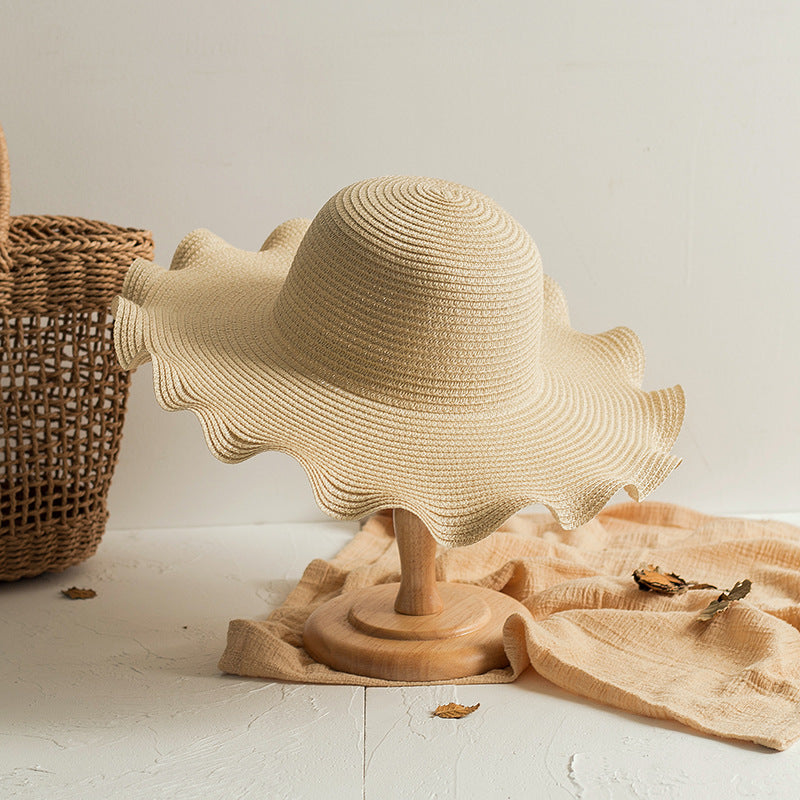 A Foldable Wavy Edge Windproof Beach Hat and a basket on a table. Brand Name: Beachy Cover Ups