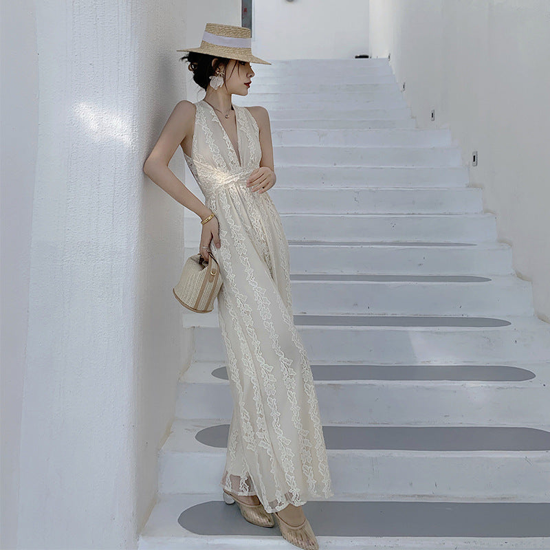 A woman in a High Waist Open Back Floral Apricot Beach Dress by Beachy Cover Ups standing on a staircase.