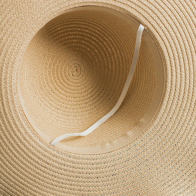 A close up of a Beachy Cover Ups Foldable Wavy Edge Windproof Beach Hat on a white surface.