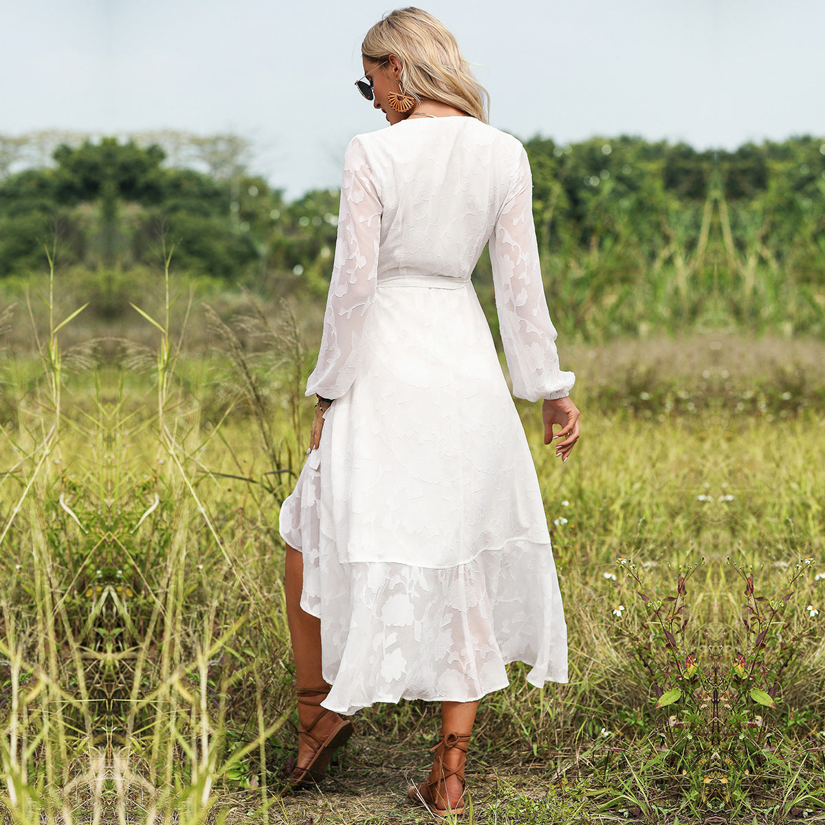 A woman in a Beachy Cover Ups Long Sleeve V Neck Beach Dress walking through a field.