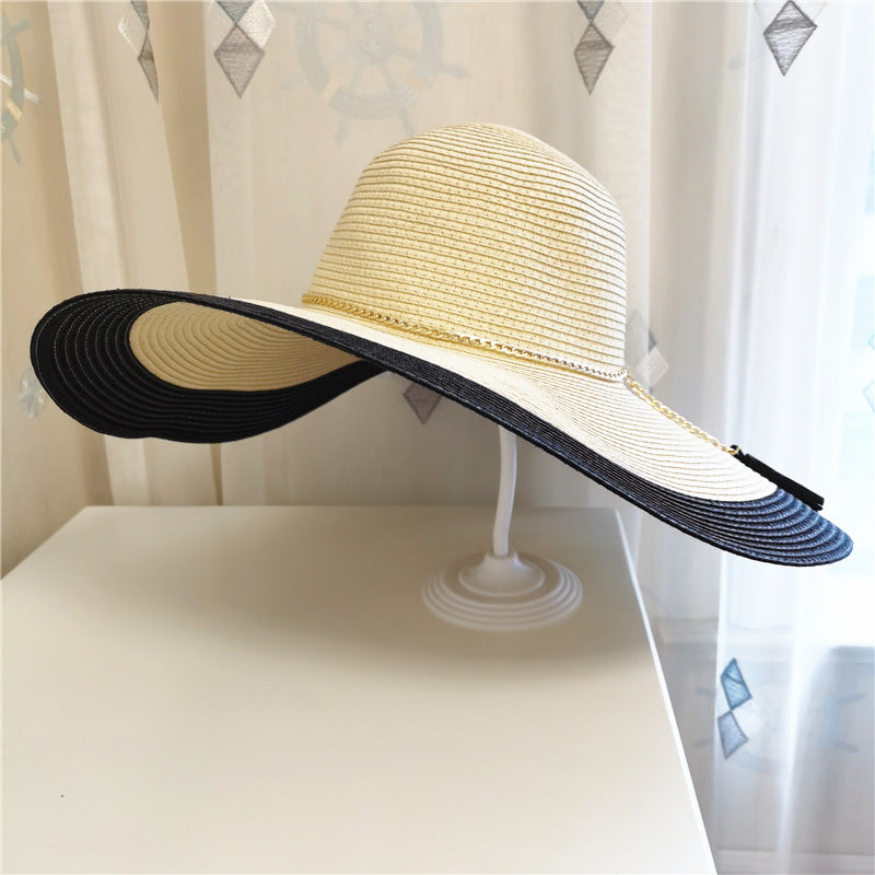 A Gold Chain Big Brim Beach Hat by Beachy Cover Ups on top of a dresser.