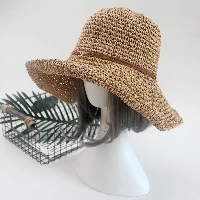 An Elegant Foldable Travel Beach Straw Hat by Beachy Cover Ups for sun-chasing adventures on a mannequin head.