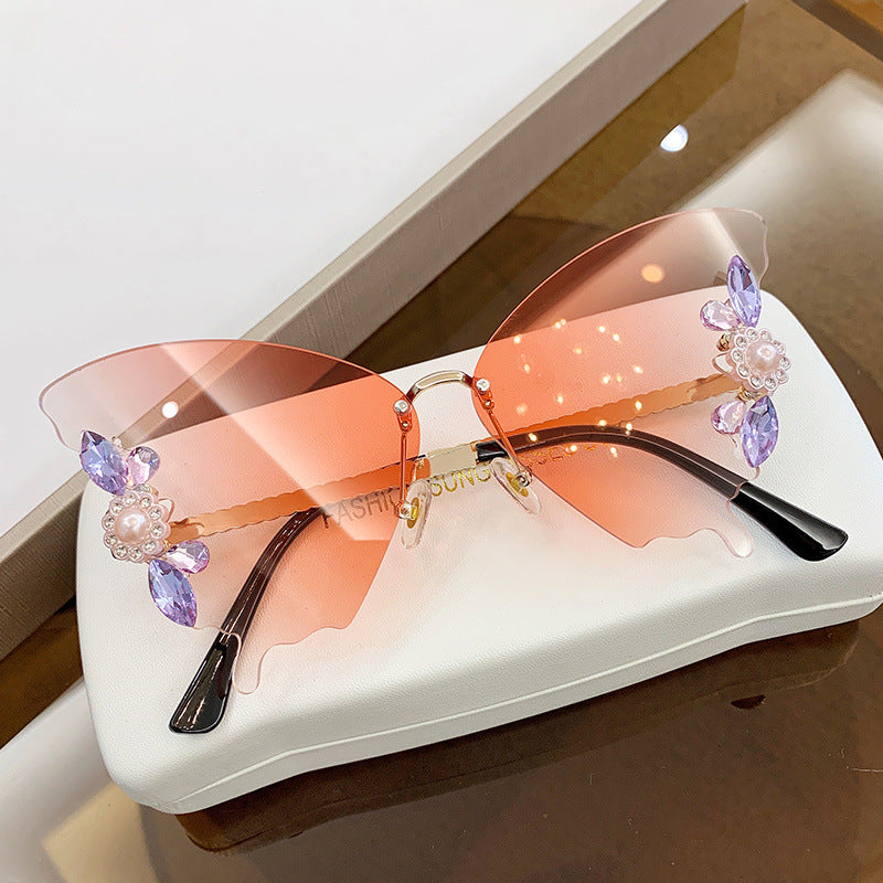 A pair of Diamond Butterfly Sunglasses by Beachy Cover Ups in a box.