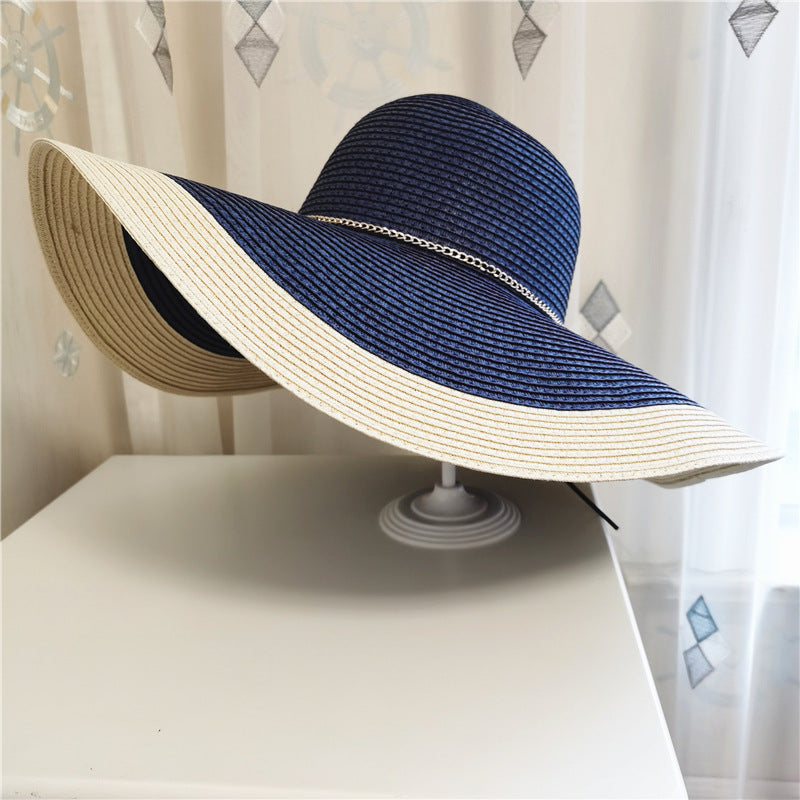 A Gold Chain Big Brim Beach Hat with a white brim on top of a dresser. (Brand: Beachy Cover Ups)