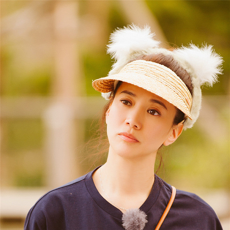 A woman wearing a Beachy Cover Ups Beach Woven Straw Sun Visor.