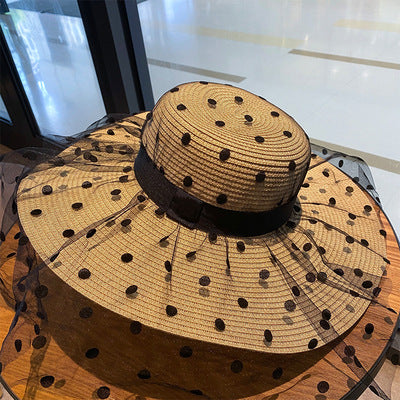 A Big Brim Lace Mesh Polka Dot Beach Hat with sun protection, designed by Beachy Cover Ups, on top of a table.