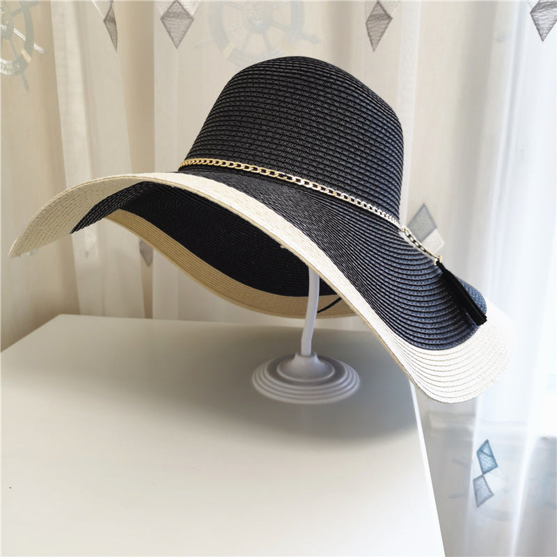 A Gold Chain Big Brim Beach Hat by Beachy Cover Ups on top of a dresser.