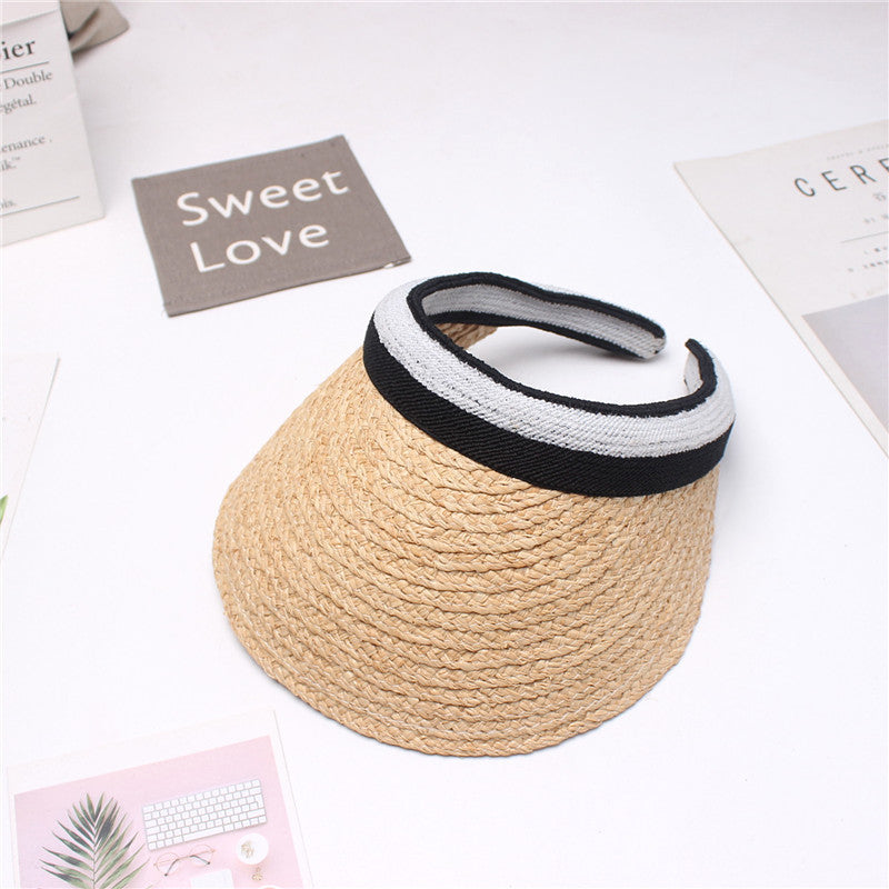 A Beachy Cover Ups Beach Woven Straw Sun Visor with a black and white band, adjustable back strap for sun protection.