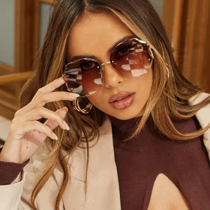 A woman is posing with Beachy Cover Ups Irregular Shaped Rimless Cut Edge Sunglasses on her face.