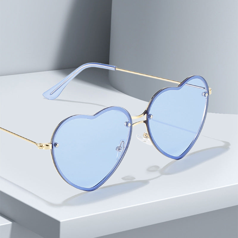 A pair of Beachy Cover Ups Heart Shaped Rimless Sunglasses in a festive blue color, serving as a stylish fashion accessory.