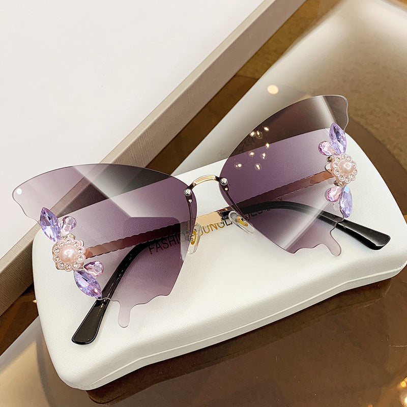 A pair of elegant Beachy Cover Ups Diamond Butterfly Sunglasses on a table.